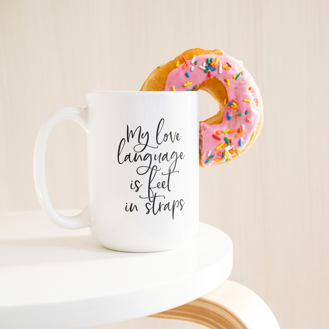 Love_Language_Is_Feet_Straps_Mug_15ozWhiteMugLifetsyleDonutLH_Mockup.png