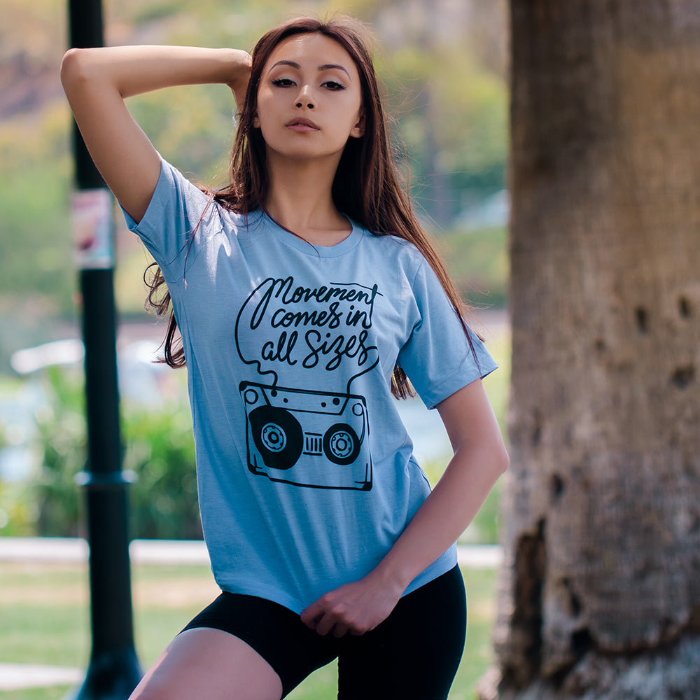 Woman wearing a blue t-shirt that says "movement comes in all sizes"