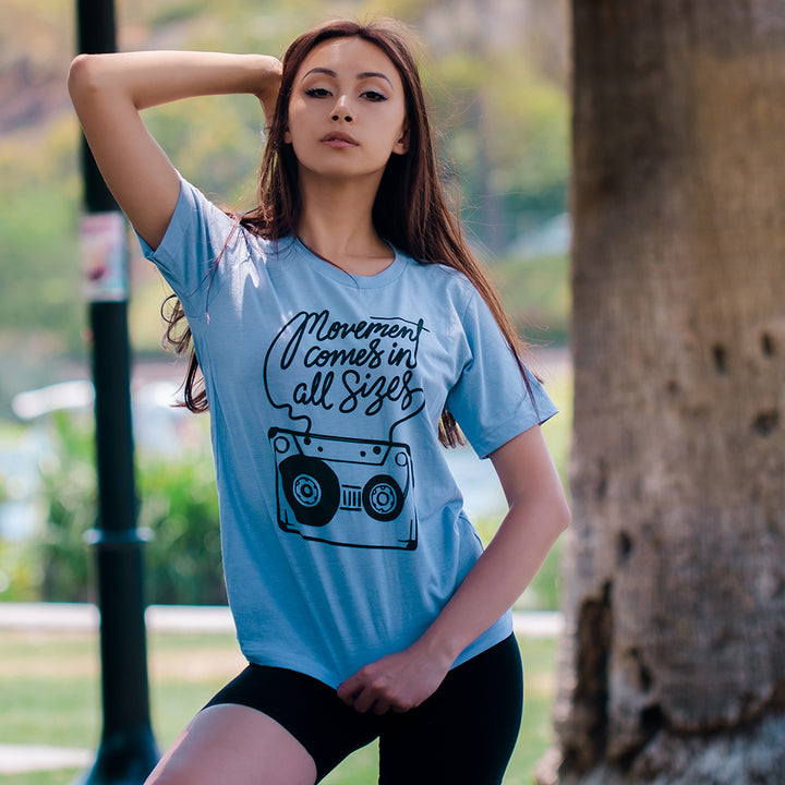 Woman wearing a blue t-shirt that says "movement comes in all sizes"