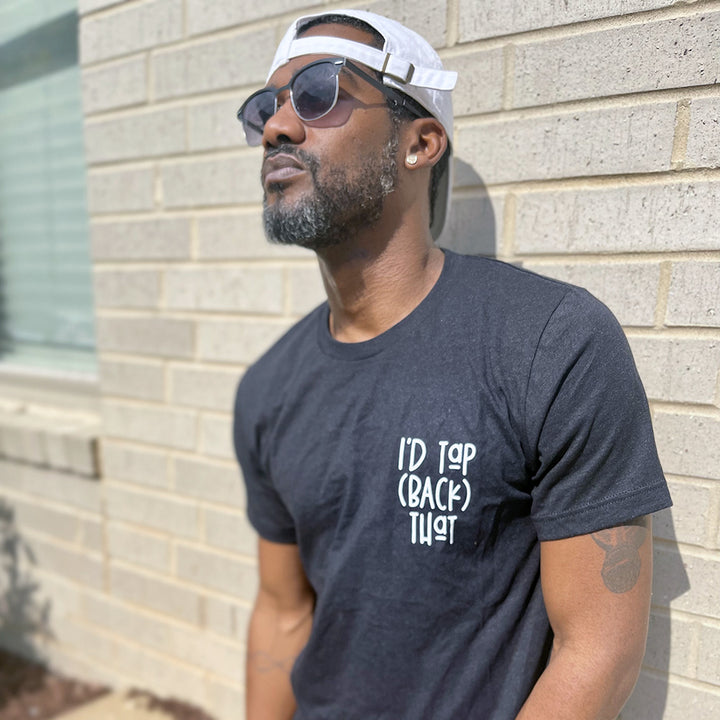 Man wearing a unisex heather black shirt from The Movement Shop that says "I'd Tap (Back) That"