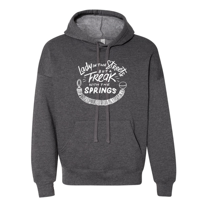 A deep heather unisex hoodie grey sweatshirt that says "Lady In The Streets But A Freak With The Springs" in white text with a pilates spring under the text.