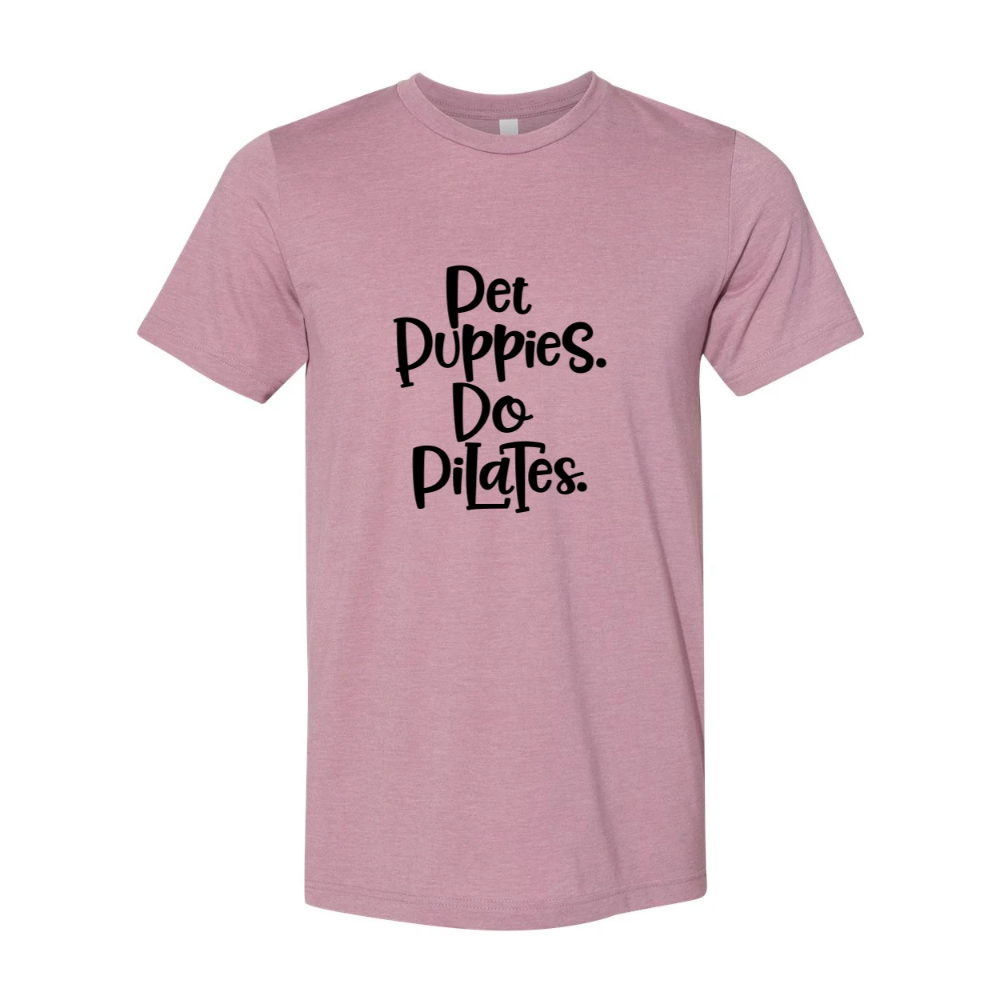 Woman wearing a unisex crewnecek Heather Orchid t-shirt that says "Pet Puppies, Do Pilats" in black text