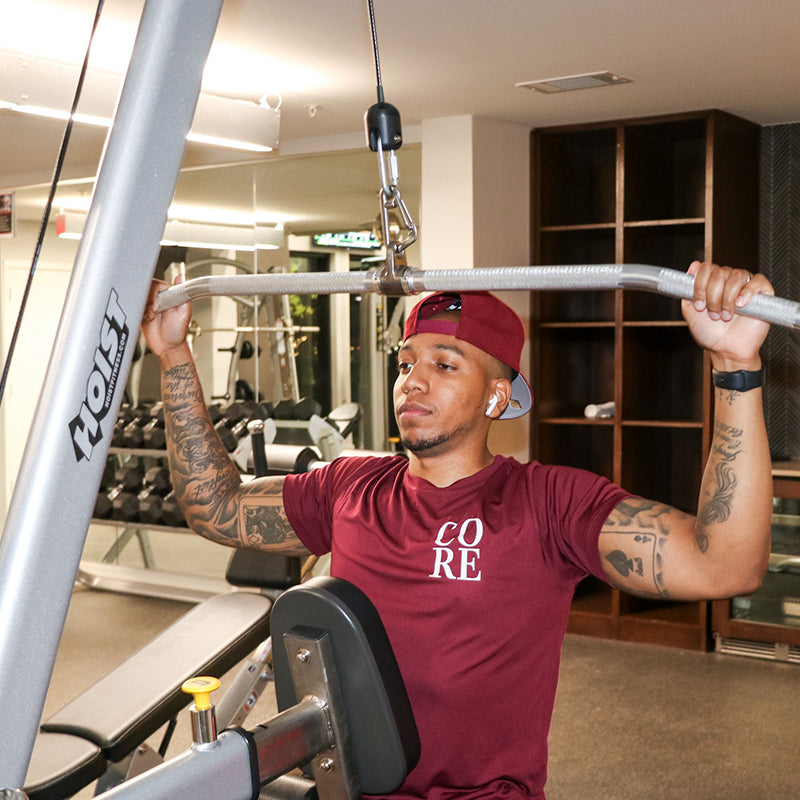 Man wearing a burgandy t-shirt that says CORE in the upper right chest logo area