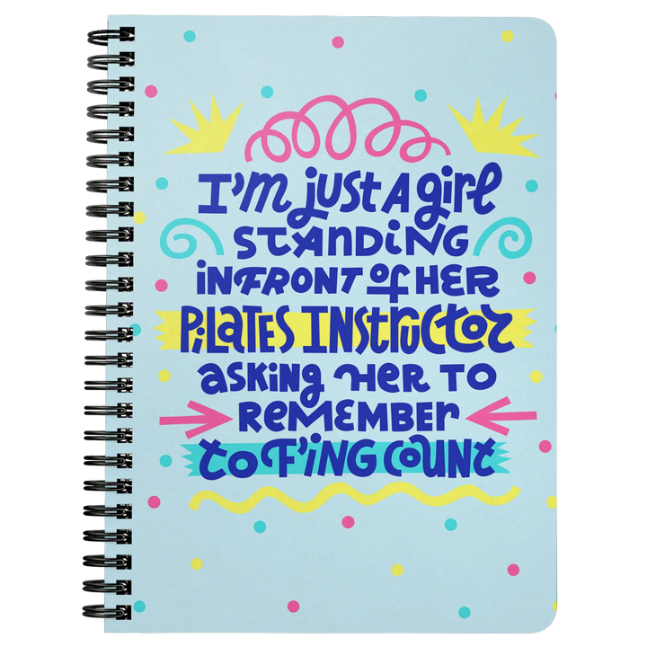 Spiral bound blue notebook that says "I'm just a girl standing in front of her pilates instructor asking her to remember to f'ing count"