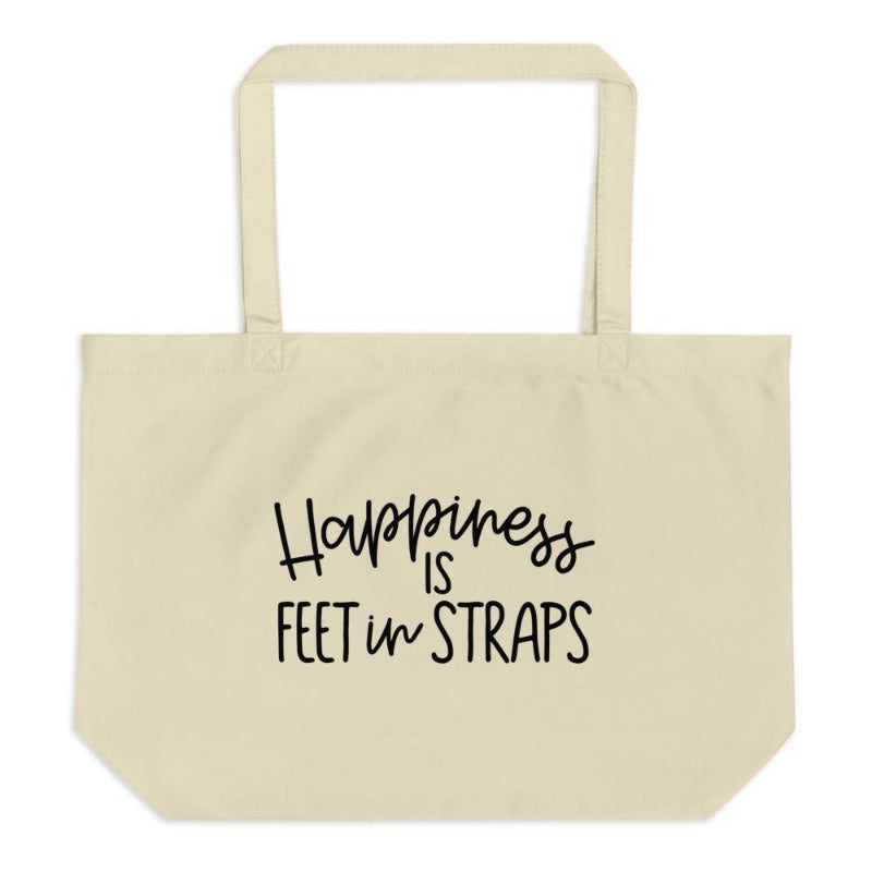 Canvas tote bag.  The front of the pilates tote bag reads "Happiness Is Feet In Straps" in black cursive