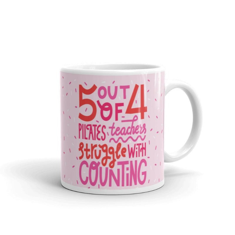 11 oz white coffee mug that says 5 out 4 Pilates Teachers struggle with counting. Mug has a white base and text is pink and white with the design.