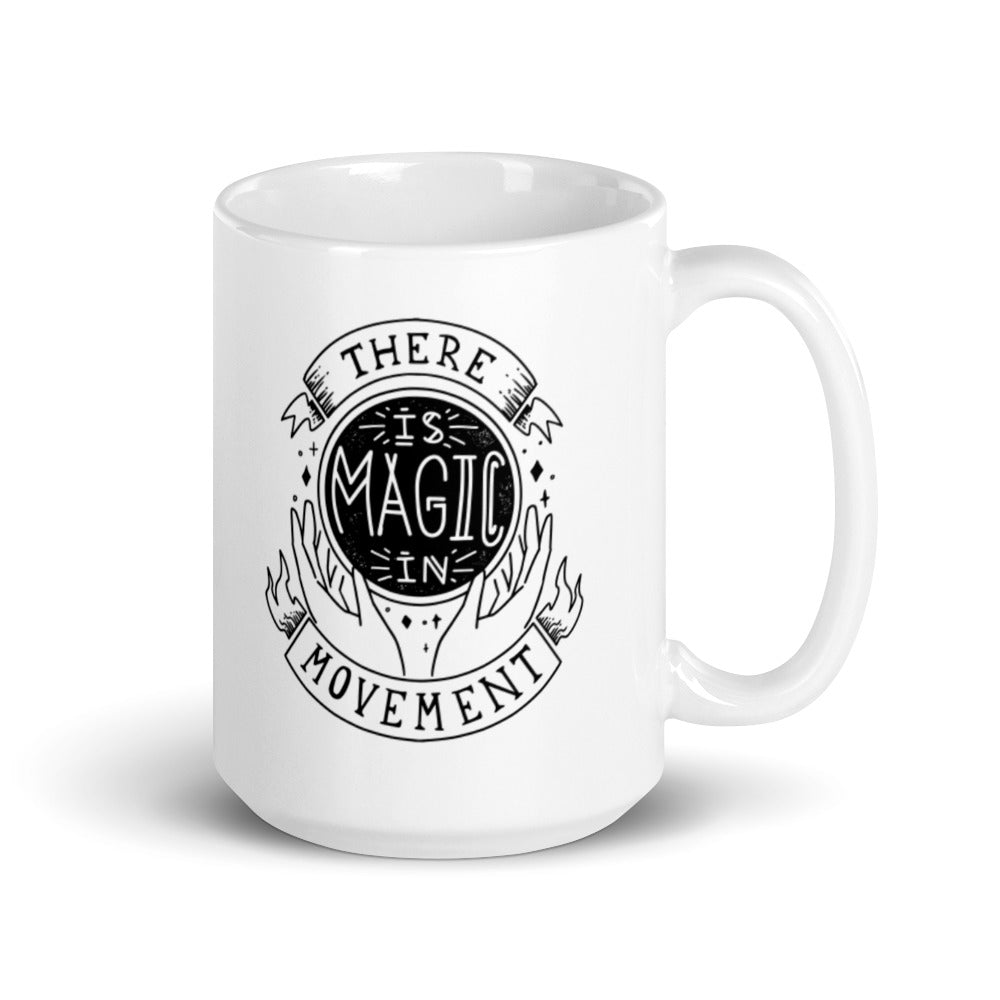 15 oz coffee mug that says "there is magic in movement" in black text.