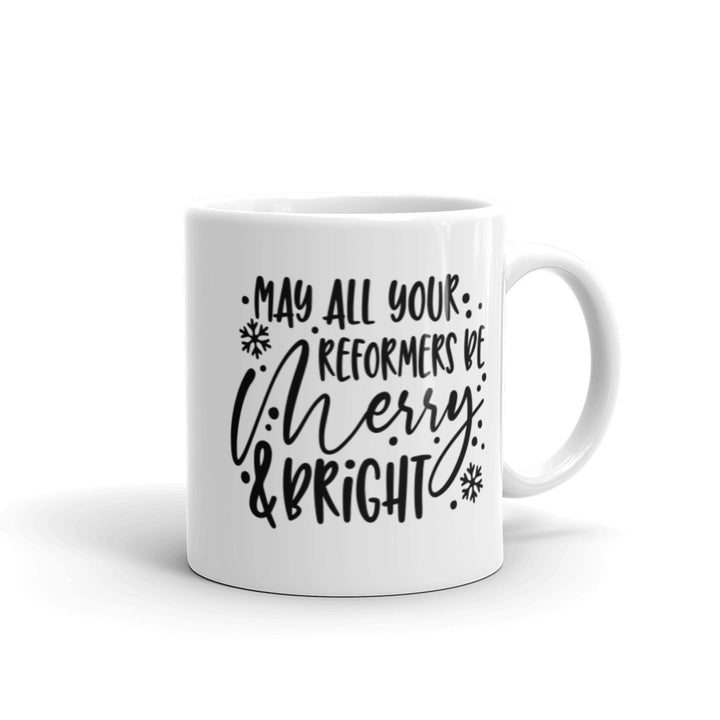 11oz white coffee mug that says "May All Your Reformers Be Merry and Bright" in Christmas style black text.