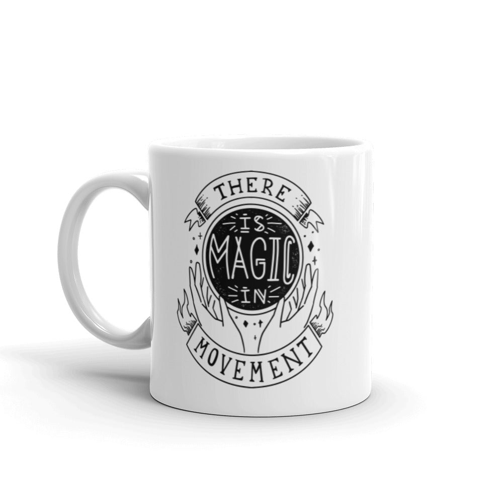 11 oz. coffee mug that says there is magic in movement in black text. Coffee mug is white.