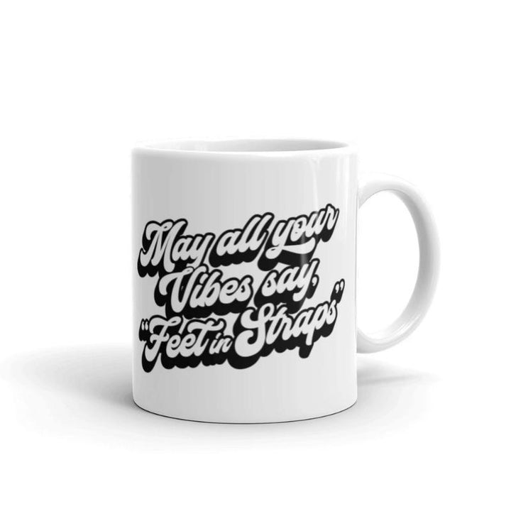 11oz white coffee mug that says "May all your vibes say Feet In Straps" in retro black font