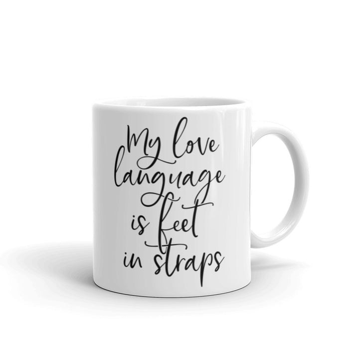 White 11oz coffee mug that says "My Love Language Is Feet In Straps" black script