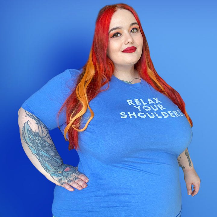 Woman wearing a heather columbia unisex crewneck t-shirt that says "Relax Your Shoulders" in white text