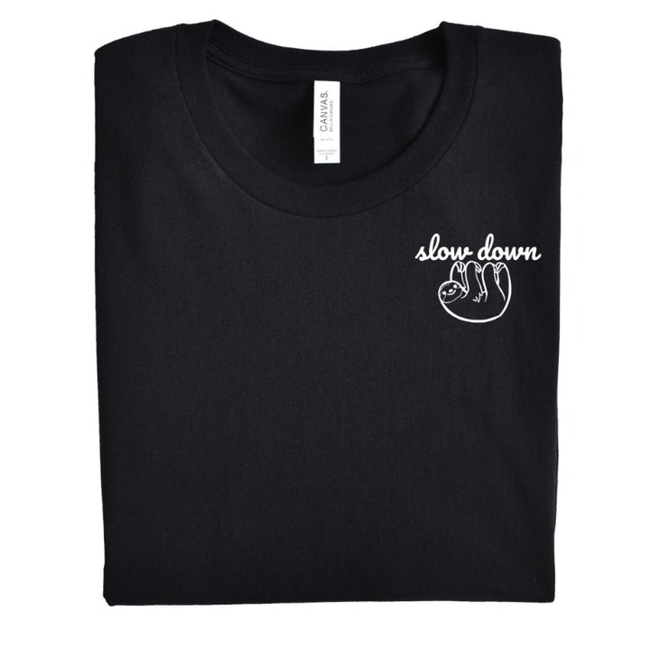 Folded Heather Black Unisex Crewneck T-Shirt that has the text "slow down" in white script over a white sloth on her left chest logo.