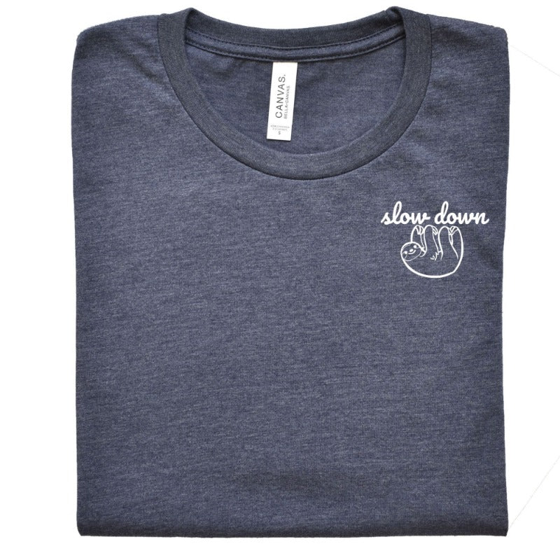 Folded Heather Navy Unisex Crewneck T-Shirt that has the text "slow down" in white script over a white sloth on her left chest logo.