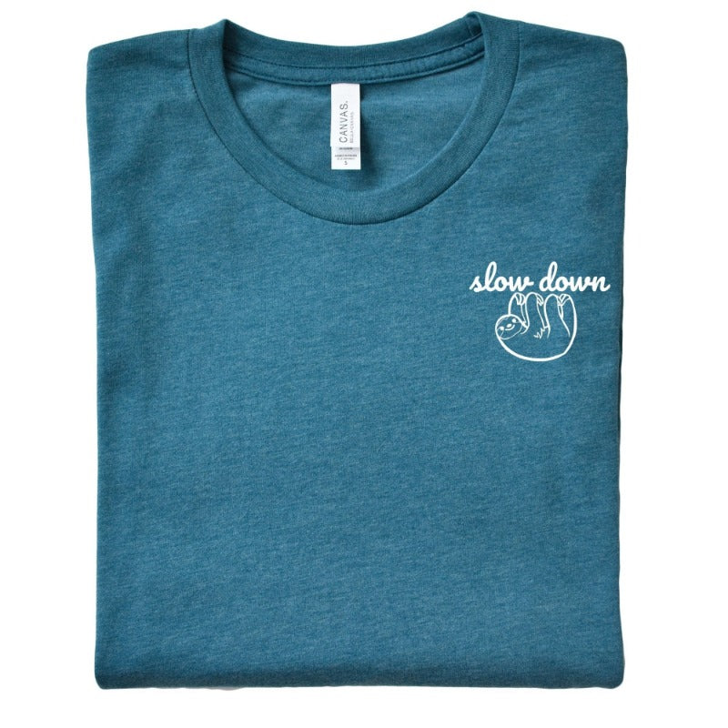 Folded Heather Deep Teal Unisex Crewneck T-Shirt that has the text "slow down" in white script over a white sloth on her left chest logo.