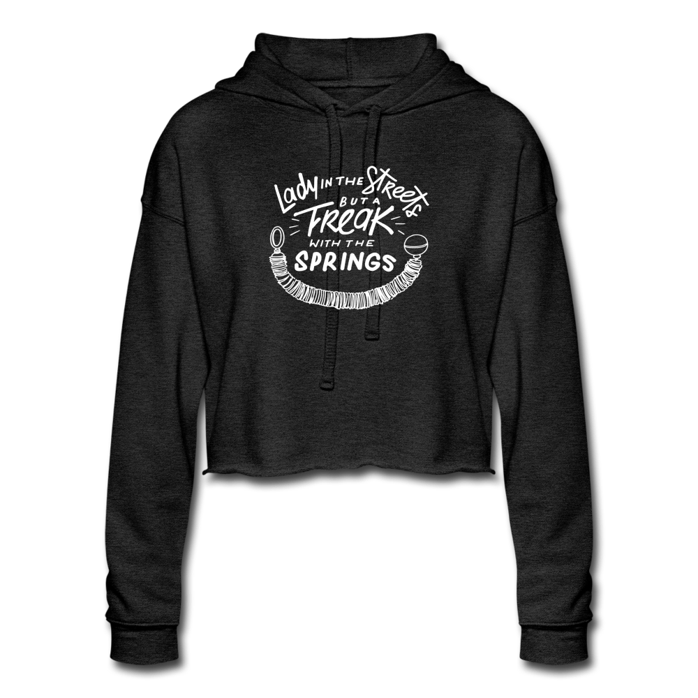 Black Women's Cut Crop Fleece Hoodie That says Lady in The Streets But A Freak With The Springs in White text. There is a design of a pilates spring on the bottom.