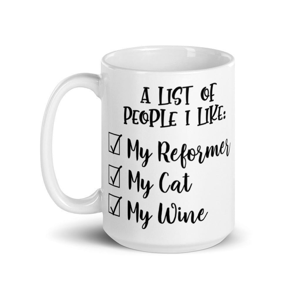 15 oz white coffee mug that says "A list of people I like: My reformer, My Cat, My Wine".