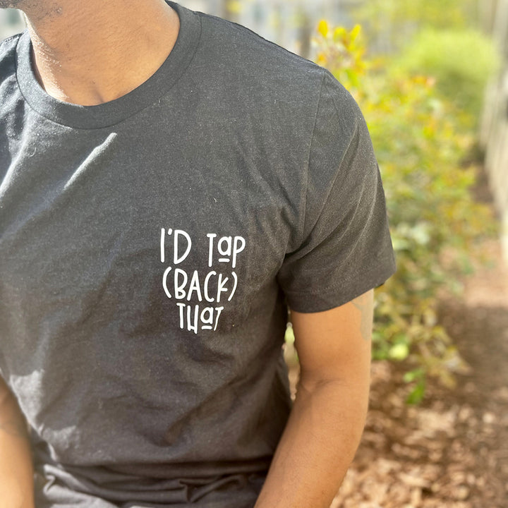 Man wearing a unisex heather black shirt from The Movement Shop that says "I'd Tap (Back) That"