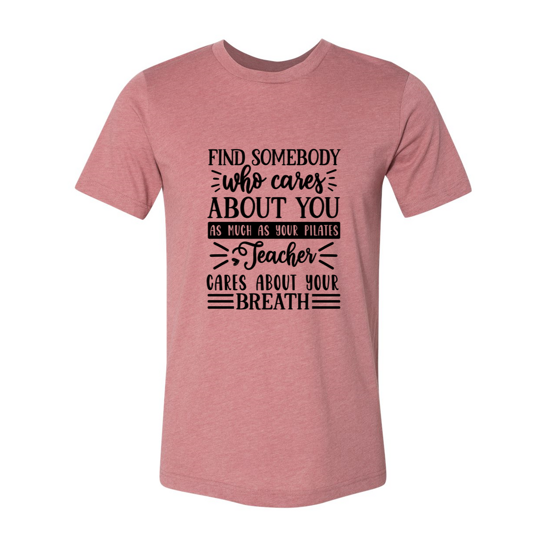 Woman wearing a unisex crewneck heather mauve t-shirt that says "Find Somebody Who Cares About You As Much As Your Pilates Teacher Cares About Your Breath" 
