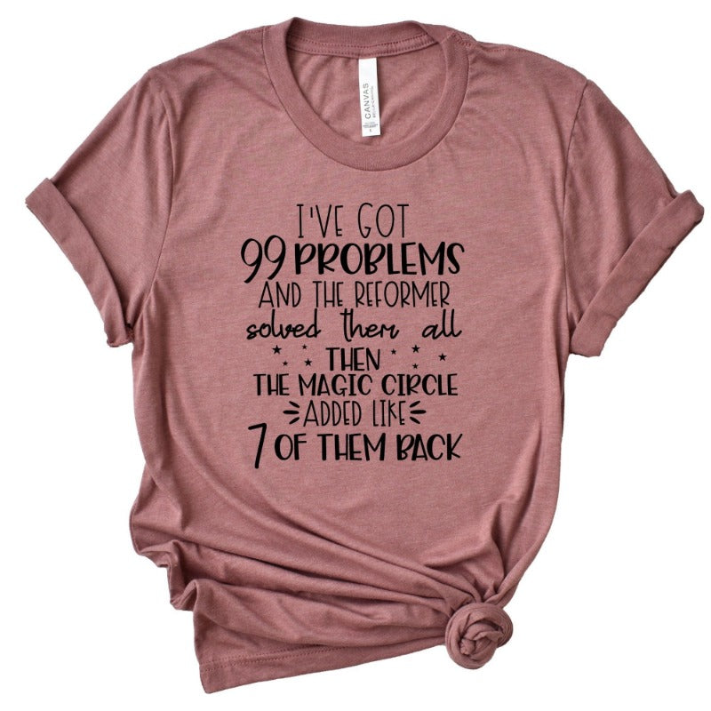 A heather mauve unisex crew t-shirt that says "I've got 99 problems and the reformer solved them all then the magic circle added like 7 of them back"