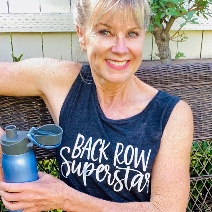 Woman wearing a black muscle tank top that says "back row super star"