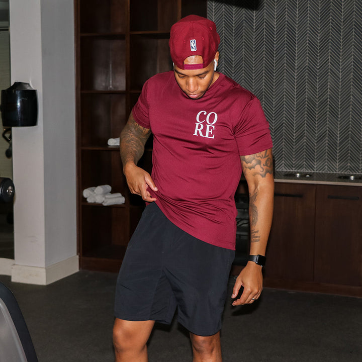 Man wearing a burgandy t-shirt that says CORE in the upper right chest logo area
