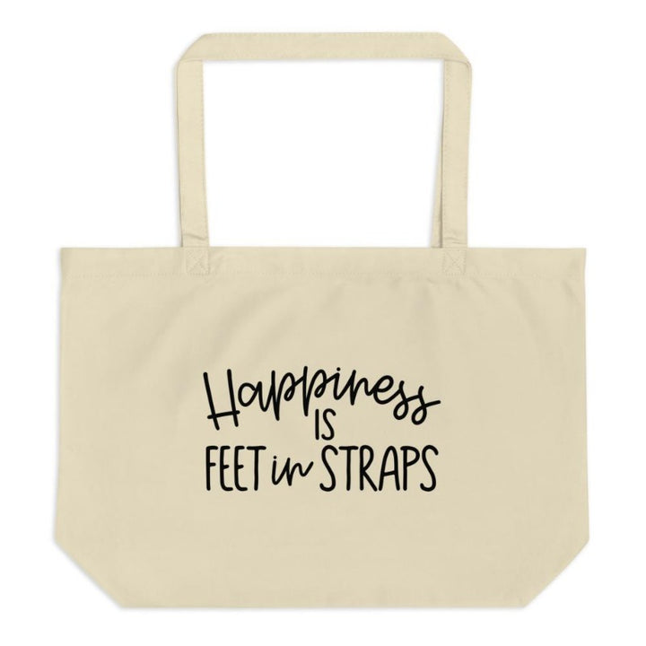 Canvas tote bag.  The front of the pilates tote bag reads "Happiness Is Feet In Straps" in black cursive