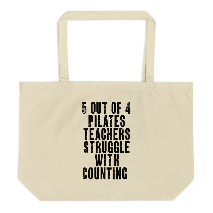 Canvas tote bag that is on the back of a white chair. Tote bag says "5 out of 4 Pilates Teachers Struggle With Counting" on one side.