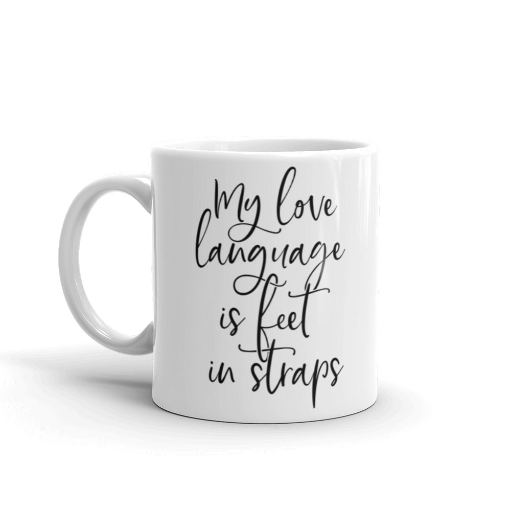 White 11oz coffee mug that says "My Love Language Is Feet In Straps" black script 