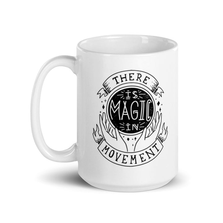 15 oz. white coffee mug that says "There is Magic In Movement". Handle is on left side.