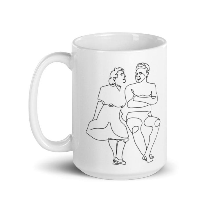 15 oz white coffee mug that with a single. Drawing is on both sides. ine drawing of Clara Pilates and Joe Pilates. Drawing is on both sides of the mug.