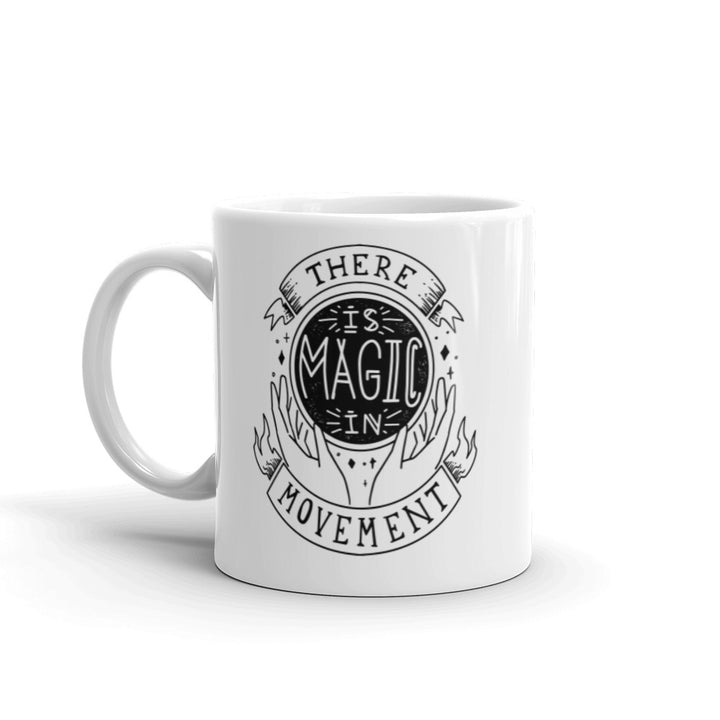 11 oz. coffee mug that says there is magic in movement in black text. Coffee mug is white. 