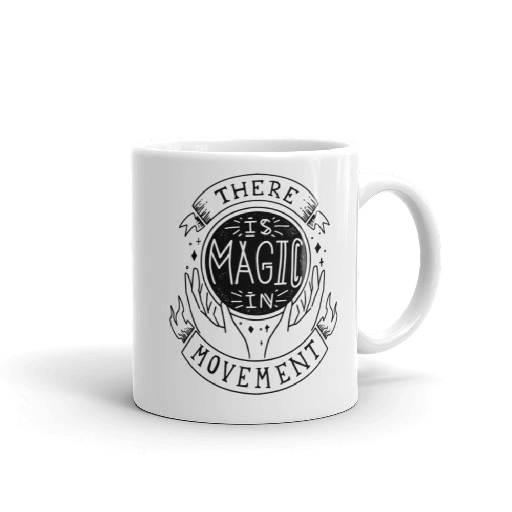 11 oz. white coffee mug with handle on right side that says "There is Magic In Movement" and is designed to look like a crystal ball
