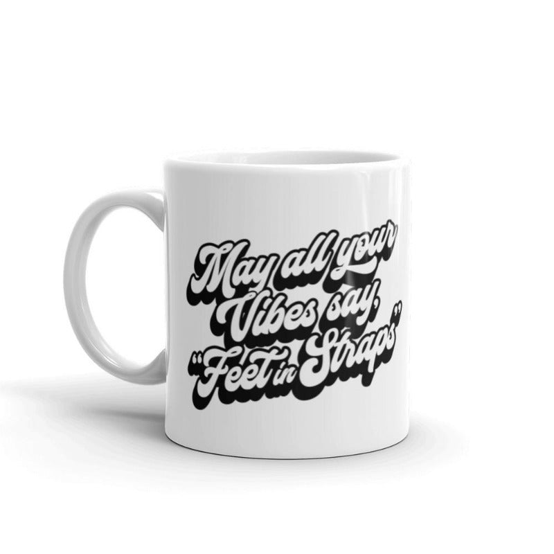 11oz white coffee mug that says "May all your vibes say Feet In Straps" in retro black font