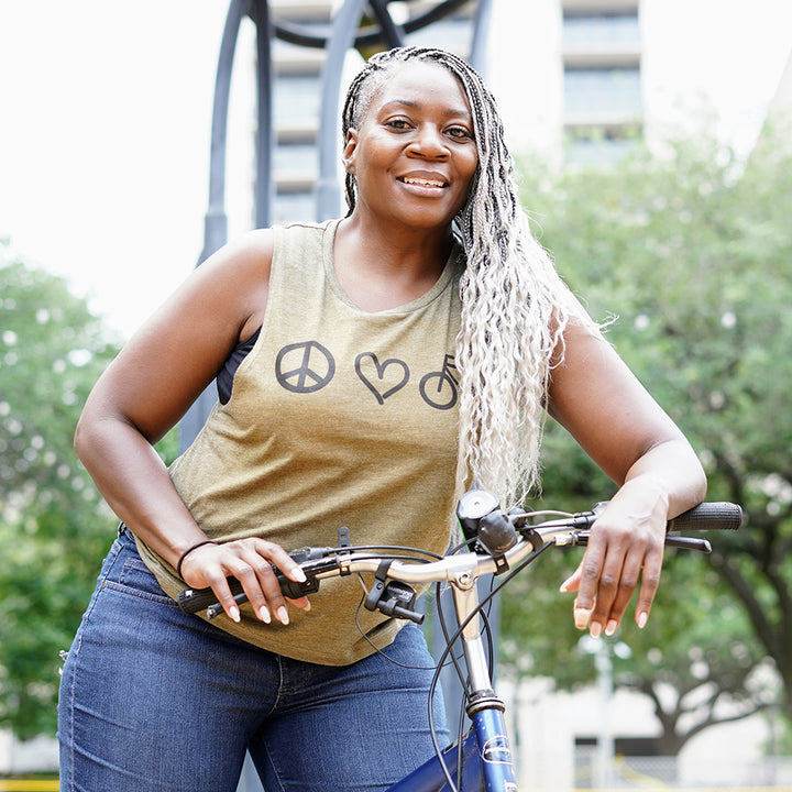 woman wearing a green muscle tank top that says "peace love biking" 