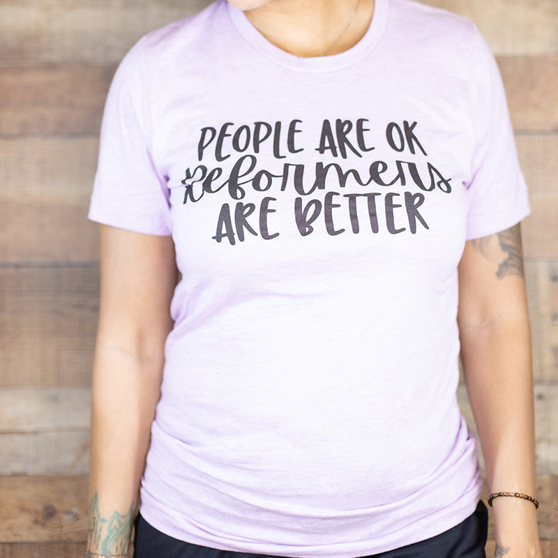 A heather lilac unisex crewneck t-shirt shirt that says "People Are Ok, Reformers Are Better" in black text