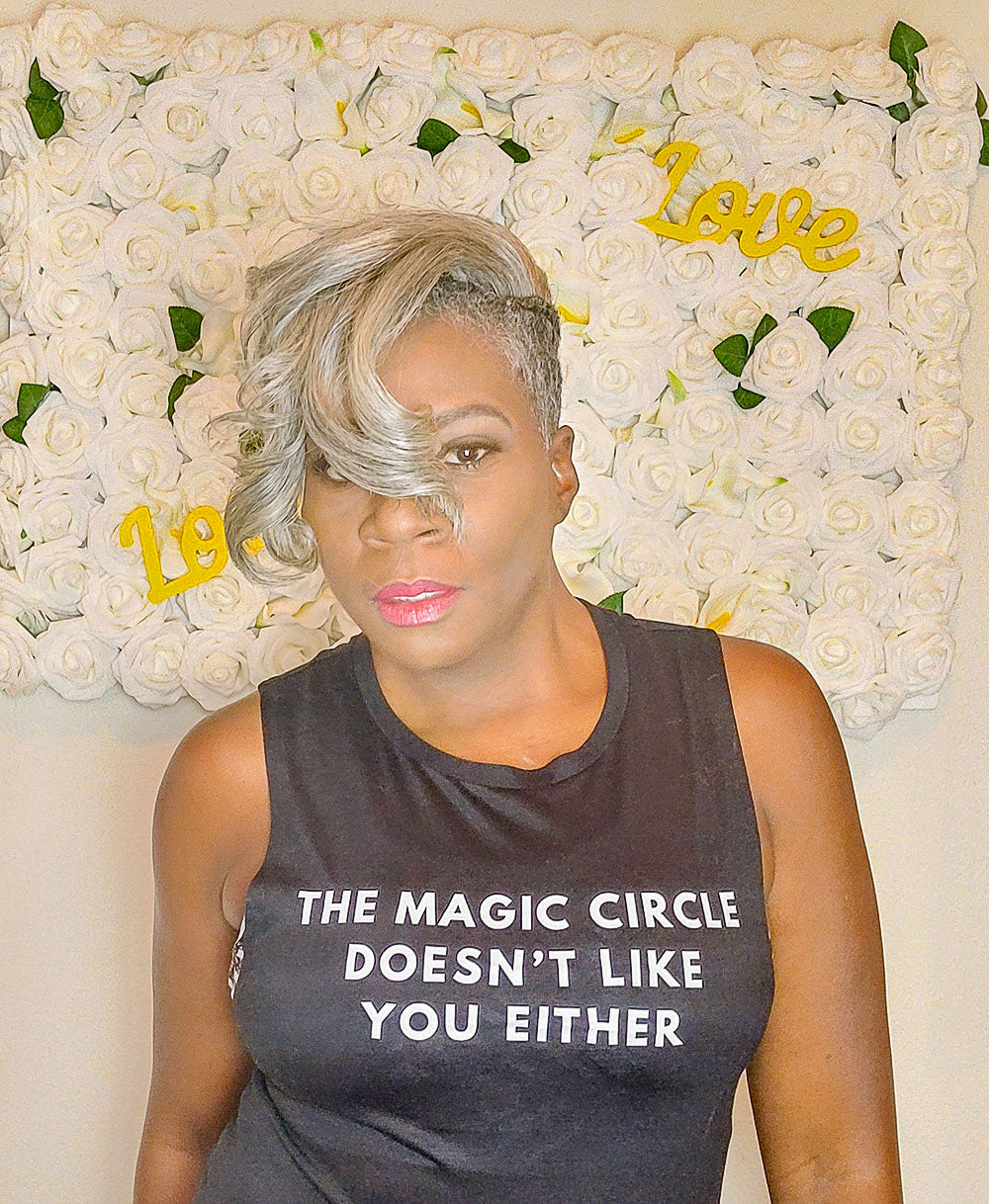 Woman wearing a black muscle tank top that says "The Magic Circle Doesn't like you either" in white all caps text.