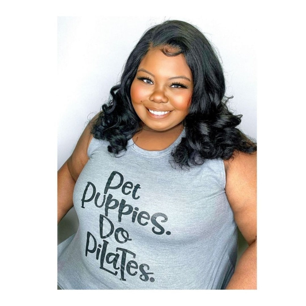 Woman wearing a grey woman's cut muscle tank top that says Pet Puppies. Do Pilates. in black text. 