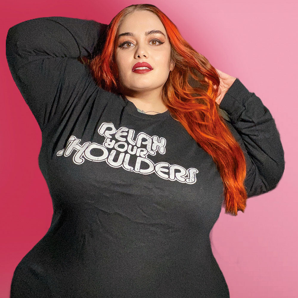Woman wearing a long sleeve black shirt that says "relax your shoulders" in retro font