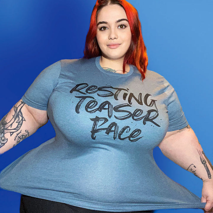 Woman wearing a heather slate unisex crew t-shirt that says "Resting Teaser Face" in black text