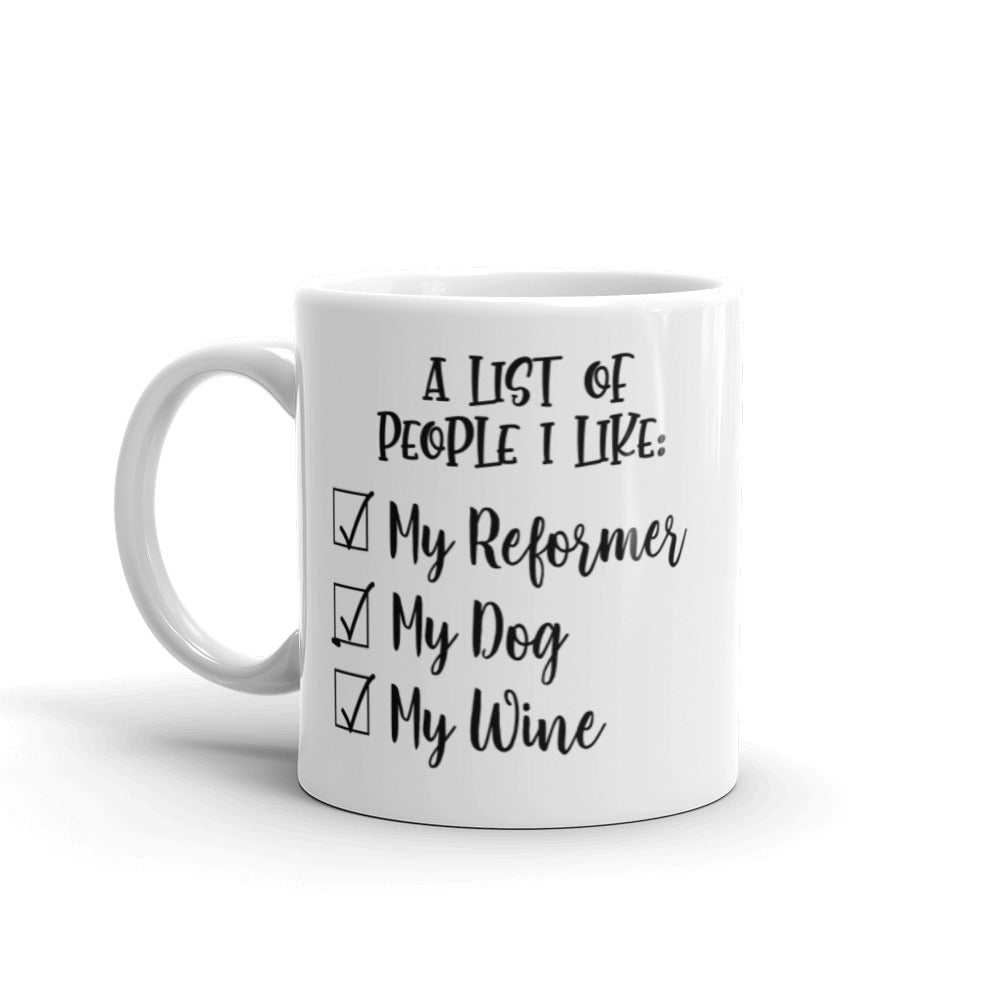 11 oz white coffee mug that says "A list of people I like: My reformer, My dog, My Wine".