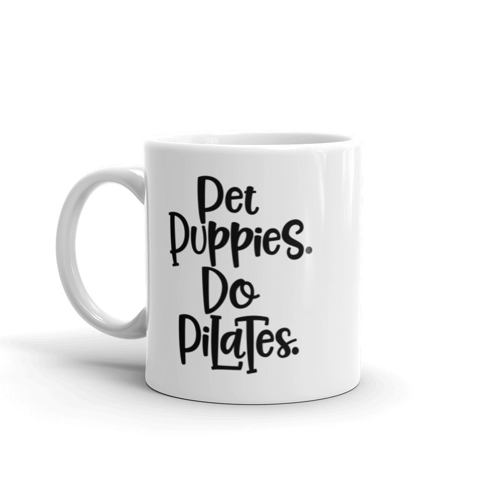 11oz white mug that has the words "Pet Puppies. Do Pilates" on the front.