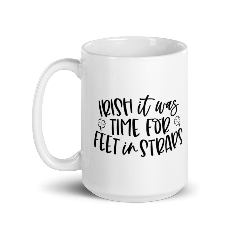 15 oz white coffee mug that says "Irish It Was Time For Feet In Straps" in black text. There are two black outline of 4 leaf clover on the front of the mug.