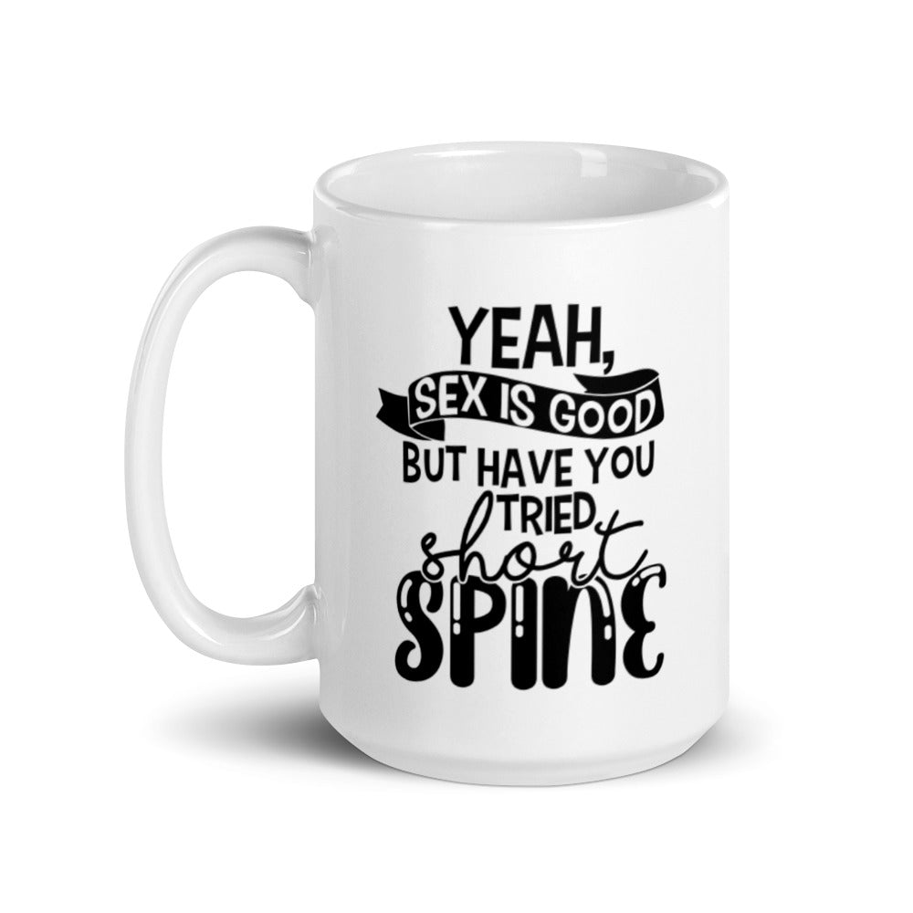 15 oz white coffee mug with handle on the left side. On the mug says " yeah, sex is good but have you tried short spine". Background is white. 