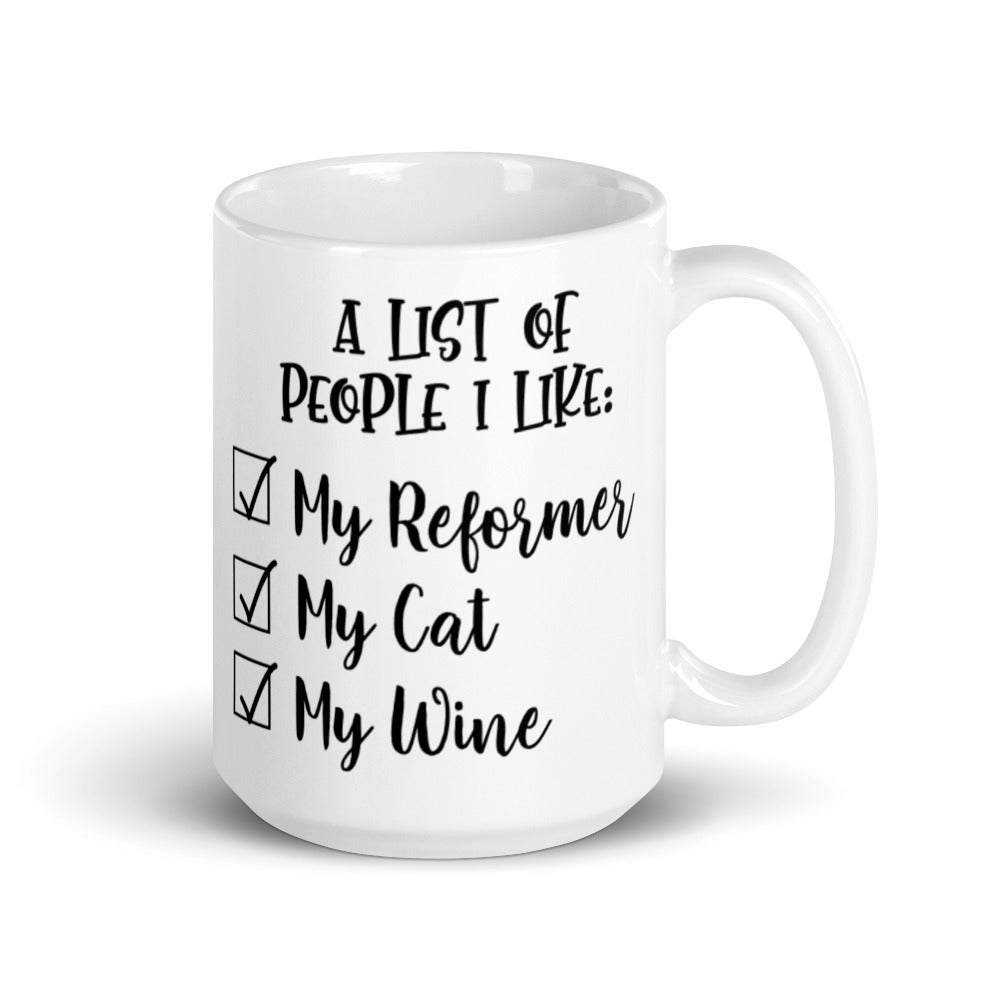 15 oz white coffee mug that says "A list of people I like: My reformer, My Cat, My Wine". 